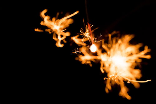 弾けた線香花火の火花が光る夜間の瞬間