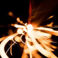 暗闇の中で光が飛び散る線香花火の光跡と火花の写真