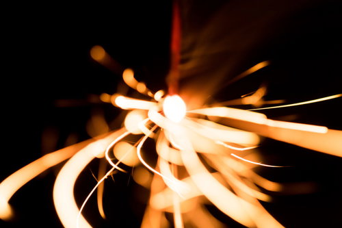 暗闇の中で光が飛び散る線香花火の光跡と火花