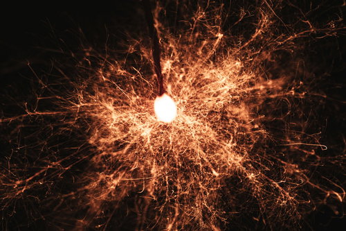 暗闇の中で激しく飛び散る線香花火の光跡と火花