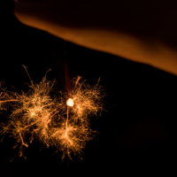 暗闇で光跡を描く線香花火で夏の夜を楽しむの写真