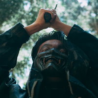 とどめを刺しに振りかぶる山賊の男性の狂気的な襲撃シーンの写真