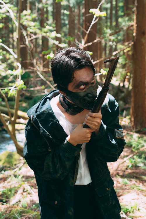 刃物を舐めるように見つめる黒マスクの山賊の男性