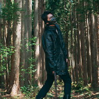 山道で出くわした山賊、黒いレインコートで立ち塞がる男性の写真