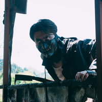 薄暗い廃屋を覗き込む野盗の男性が身を潜めて外をうかがうの写真