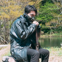 山奥で獲物を狙う野盗の男性、黒い服装で岩の上に潜むの写真