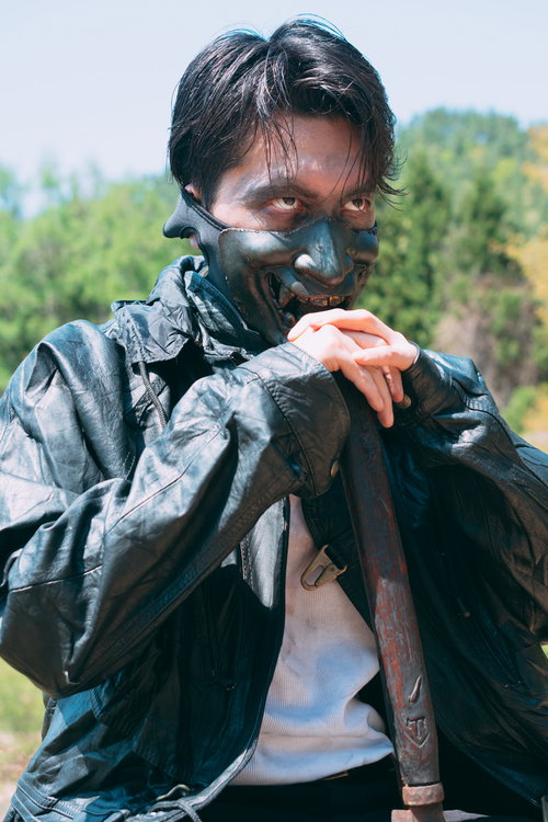 黒マスクと迷彩服に身を包む狂気的な男性の屋外撮影