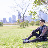野原で休息するランニング中の男性の写真