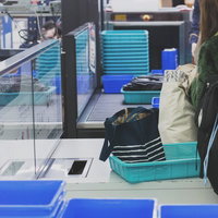 空港の手荷物検査で荷物を確認する旅行客のセキュリティチェック風景の写真