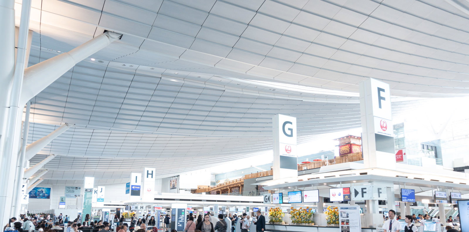 羽田空港国際線ターミナルの出発ロビーに多くの旅行者が行き交う様子