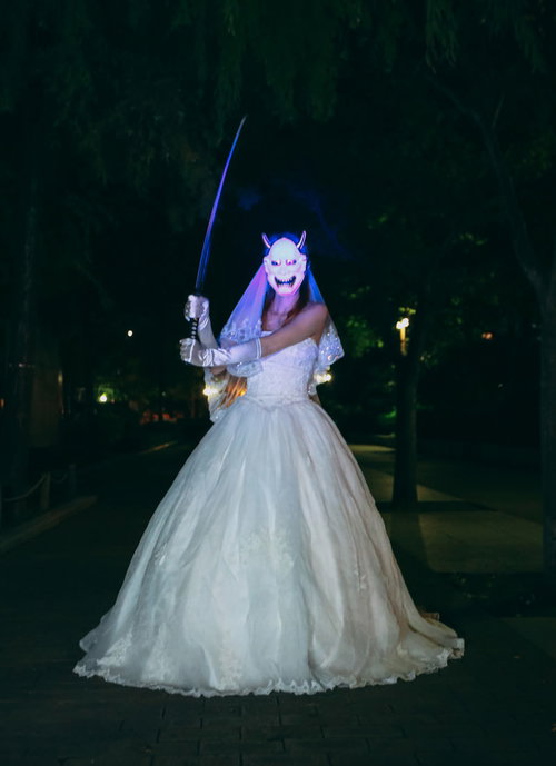 般若面を被って日本刀を振りかざすウェディングドレス姿の女性