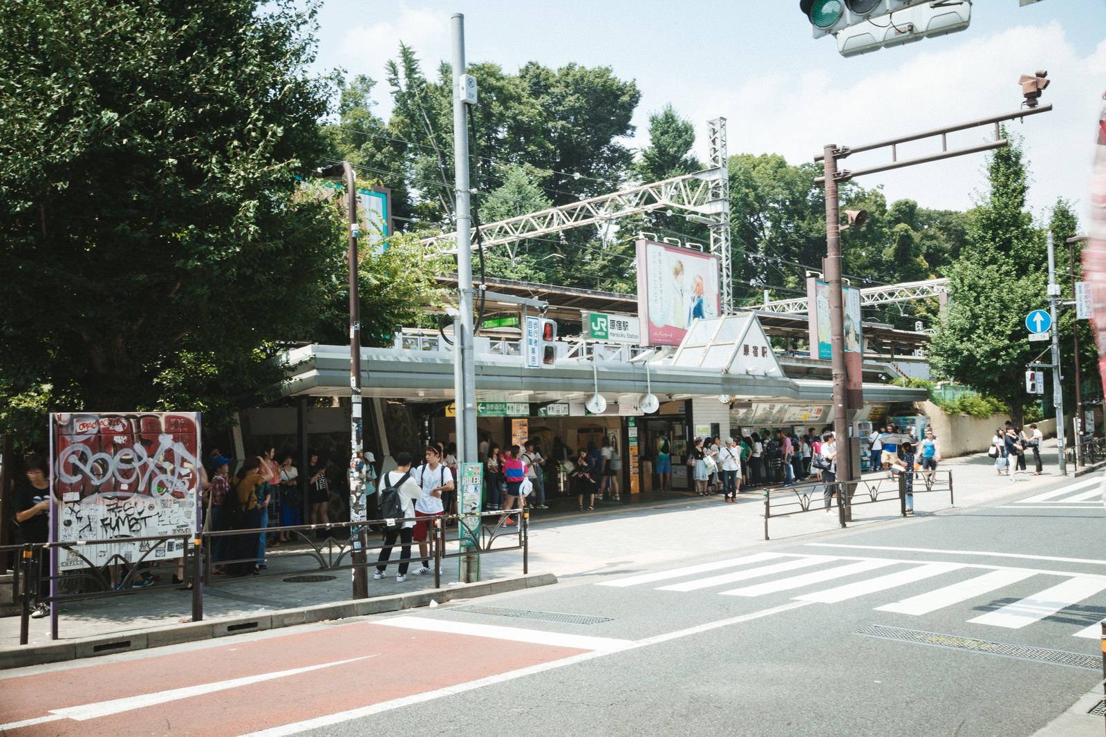 原宿駅竹下口前で多くの人々が行き交う賑やかな駅前風景