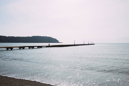 日中の原岡桟橋と穏やかな海の風景