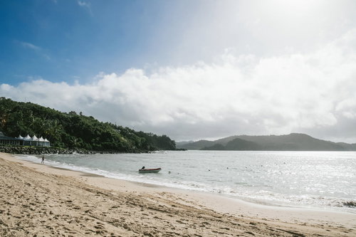 晴れた日の砂浜に停泊するボートと青い海の風景
