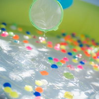 水に浮かぶカラフルなスーパーボールすくいの風景の写真