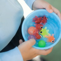 夏祭りの出店で金魚すくいの景品を手にする子供の写真