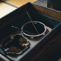 木製の箱に灰と炭が詰まった昔使われた火鉢の写真
