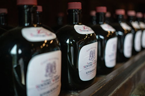 棚に整然と並ぶサントリーオールドウイスキーの黒いボトル