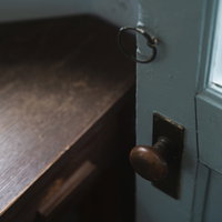 古い木製の扉に取り付けられたレトロなドアノブの写真