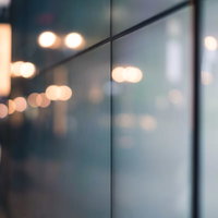 壁に反射した街灯りのボケ味が美しい夜間の光の写真