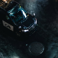 雨上がりの濡れた路面に停まるタクシーの夜間風景の写真