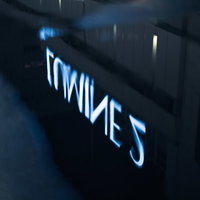 雨上がりの水たまりに反射したルミネ2の青い看板の写真