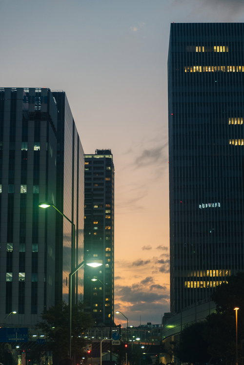 夕焼け空に佇む都会の高層ビル群と窓明かり