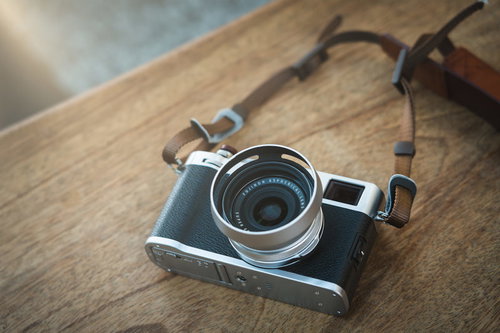 オシャレなブラウンレザーストラップとシルバーのミラーレスカメラ