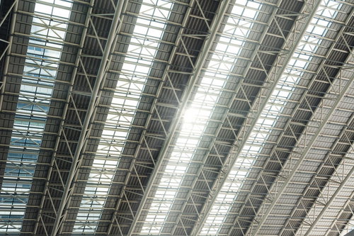 天井の構造部分から漏れる日差しと光芒、室内に広がる自然光