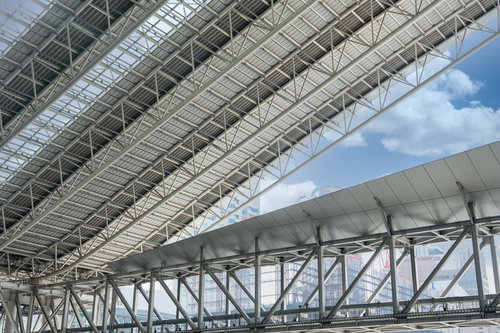 天井から覗く快晴な空と鉄骨フレームの屋根構造