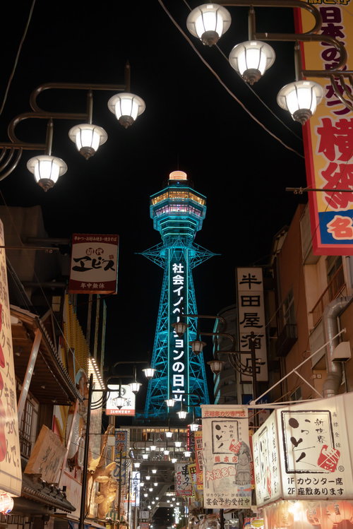 夜にライトアップされた通天閣と周囲の店看板