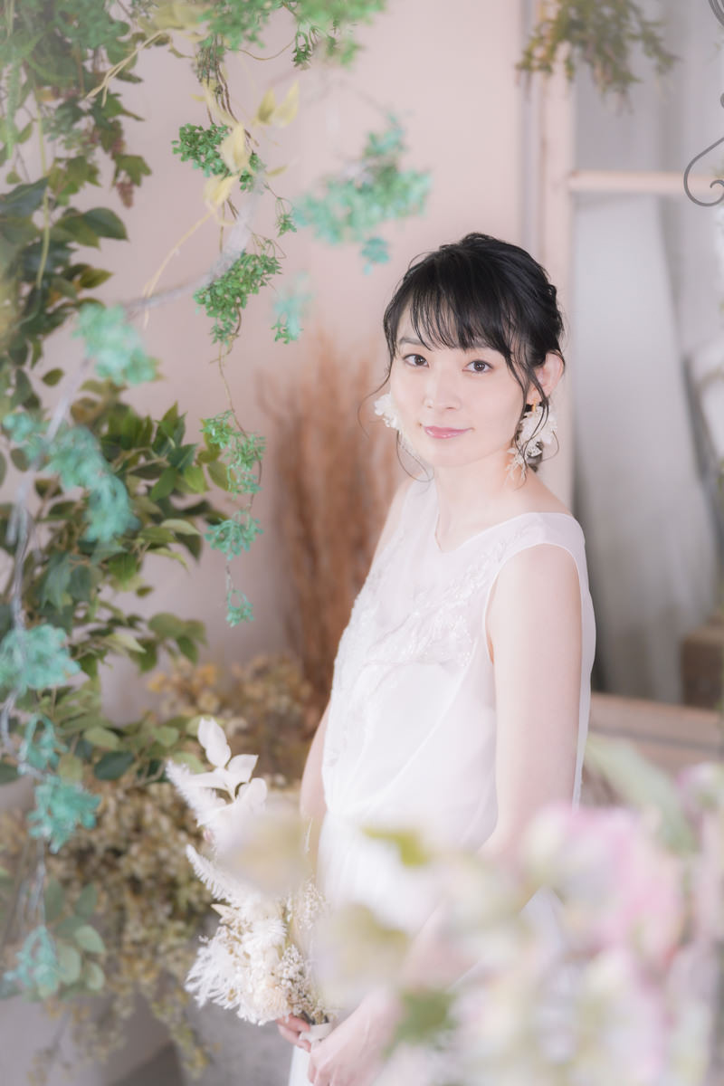 白いウェディングドレスを着て微笑む新婦の女性［モデル：たけべともこ］