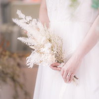 ドライフラワーのブーケを持ったウェディングドレスの女性の写真