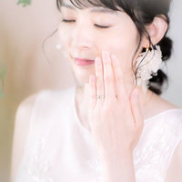 白いドレスの女性が左薬指につけた結婚指輪の写真