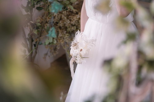 ブーケを片手に持ったウェディングドレス姿の新婦