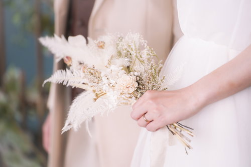 ブーケを持った新婦の左手と婚約指輪