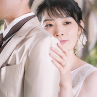 新郎の肩に寄りかかる新婦、結婚式での一瞬の写真