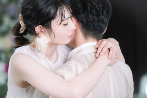 白いウェディングドレスの新婦が新郎を抱きしめる結婚式の瞬間