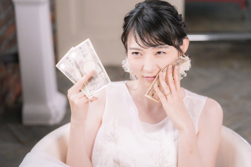 お金を浴びる玉の輿女子のウェディングドレス姿