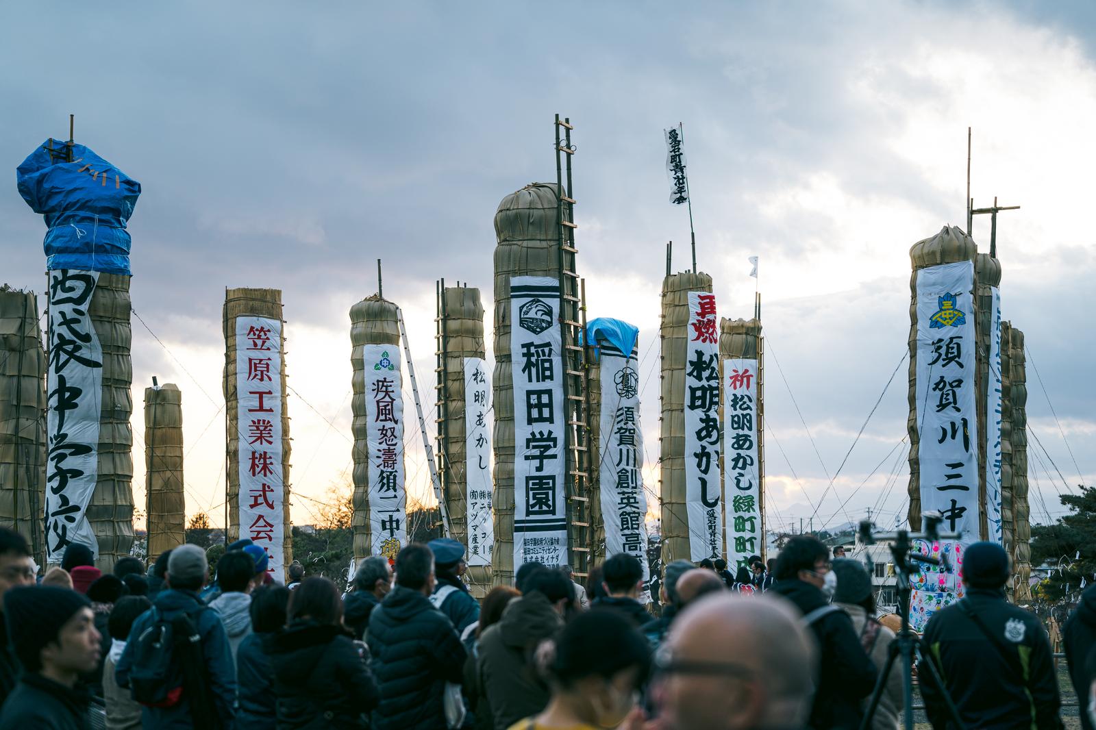 松明あかし会場で立ち並ぶ企業団体の縦断幕と大勢の見物客