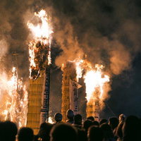 須賀川市の松明あかしで火柱を上げて燃え上がる松明と観客の写真