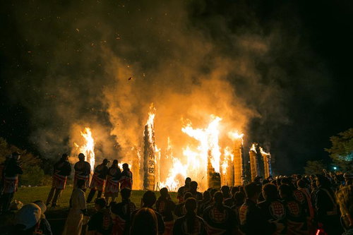 須賀川市の松明あかしで舞い上がる火柱の火花と見物人のシルエット