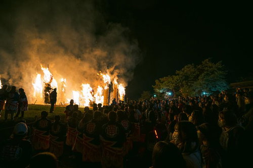 大勢の観客の顔を照らす松明あかしの大きな炎