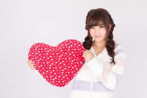 赤い水玉ハートのクッションを抱えたパジャマ女子