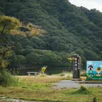 榛名湖と榛名公園の青い看板が立つ山々の風景の写真