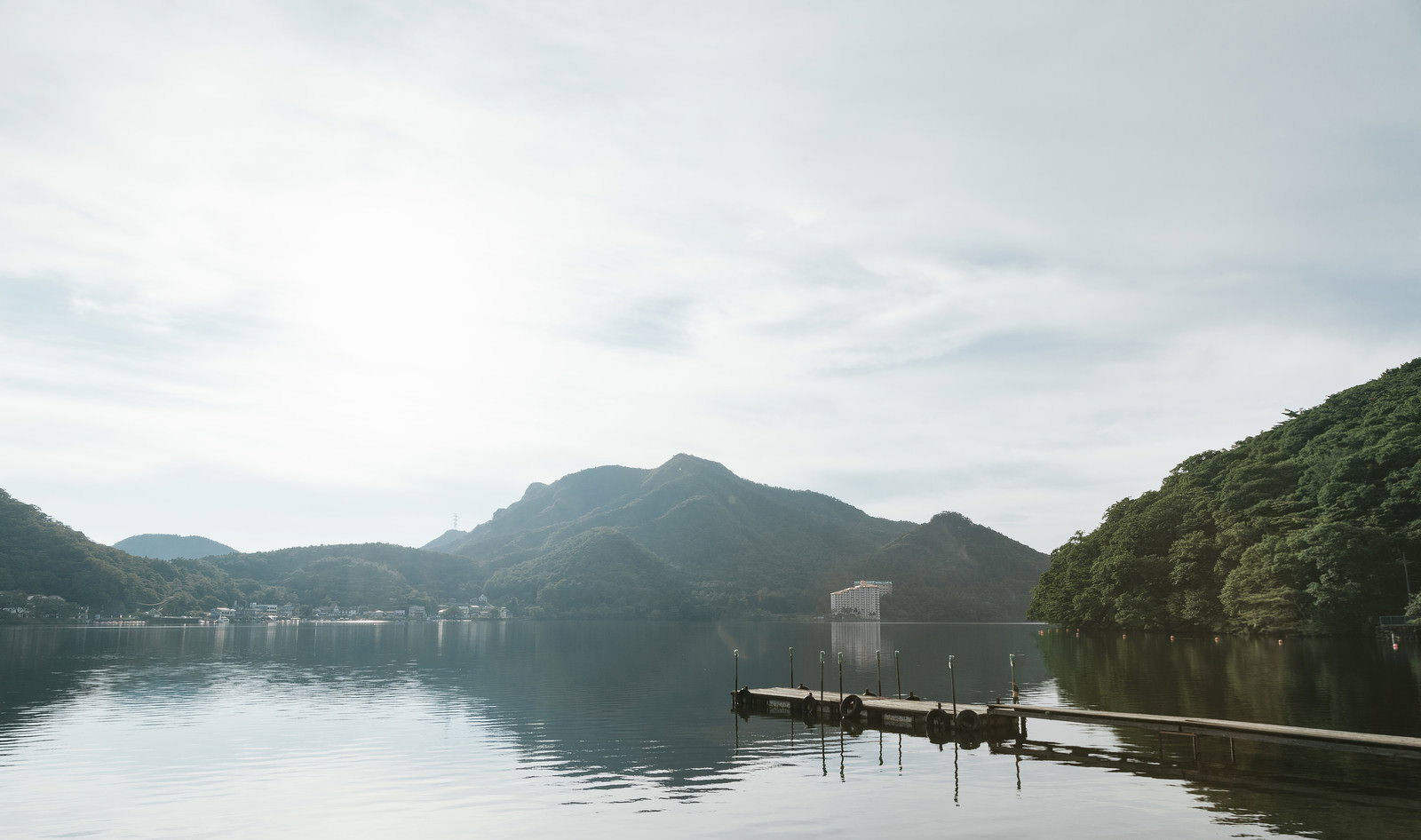 榛名湖の静かな湖面に伸びる桟橋と周囲の山々