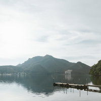 群馬県西部の榛名湖に伸びる木製の桟橋と緑の山々の写真