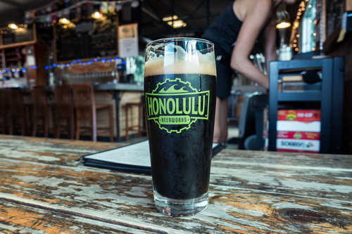 ホノルルのクラフトビールが木製テーブルに置かれた一杯