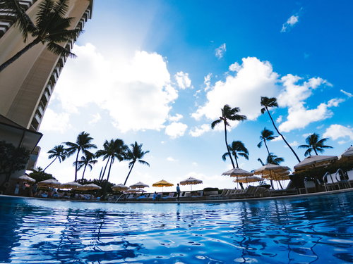 南国のリゾートホテルのプールと青空、ヤシの木