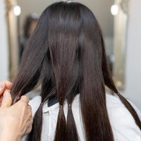 美容室でヘアドネーション前に髪の束をクリップで分ける準備工程の写真